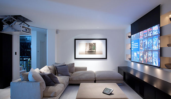 A modern home theater lounge featuring motorized scissor-lift projector system