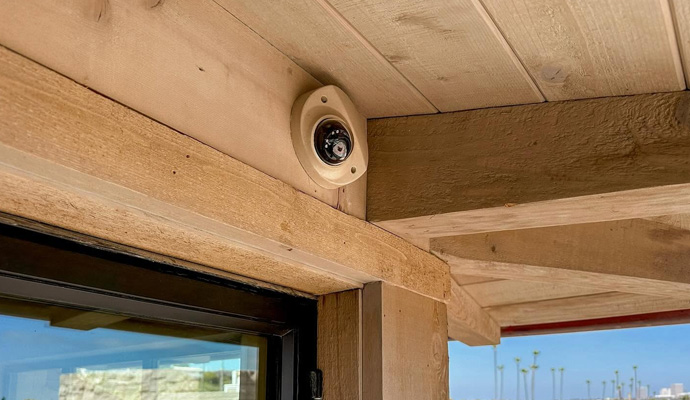 Dome security camera mounted on outdoor wooden beam