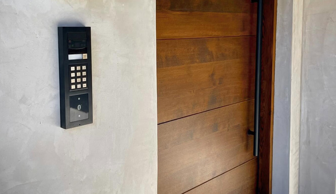 Modern entrance with wood door and smart intercom keypad