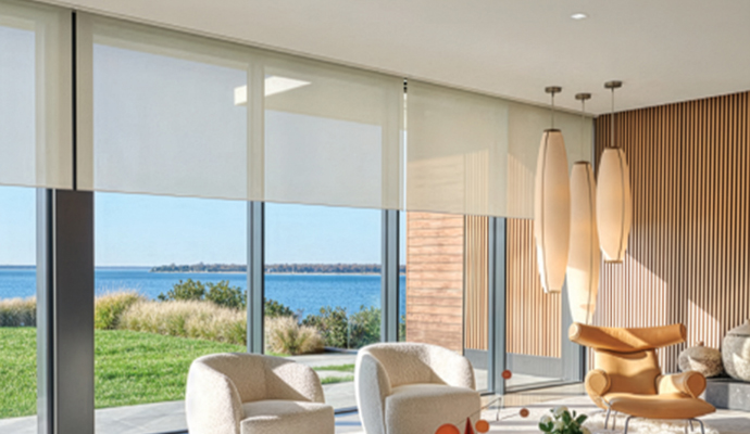 Modern lounge with motorized roller shades and water view