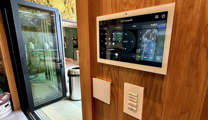 Wall mounted smart home touchscreen control panel on wood wall