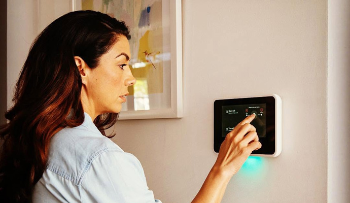 Woman using wall mounted smart home control panel
