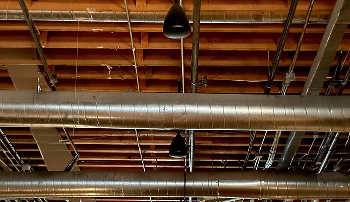 Black pendant-style speakers hanging from the ceiling