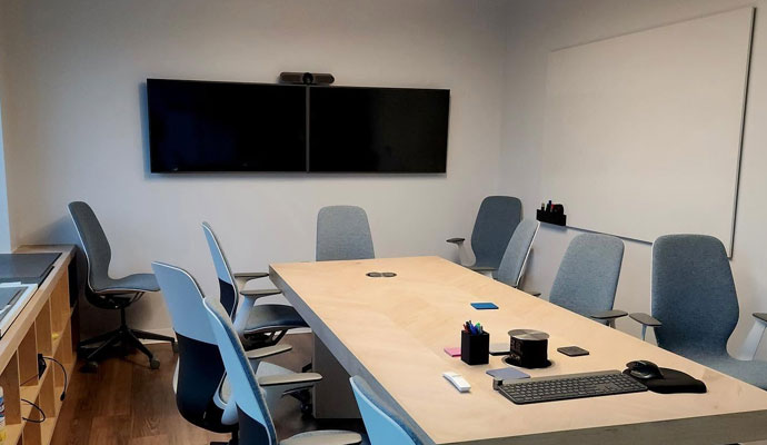 Conference room with dual monitors and video camera