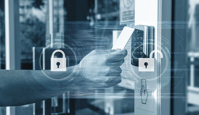 Hand holding keycard at access reader with security graphics