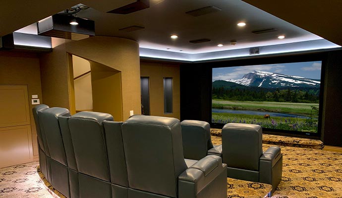 Smart luxury home theater Smart luxury home theater with leather recliners and a large screen displaying a mountain view
