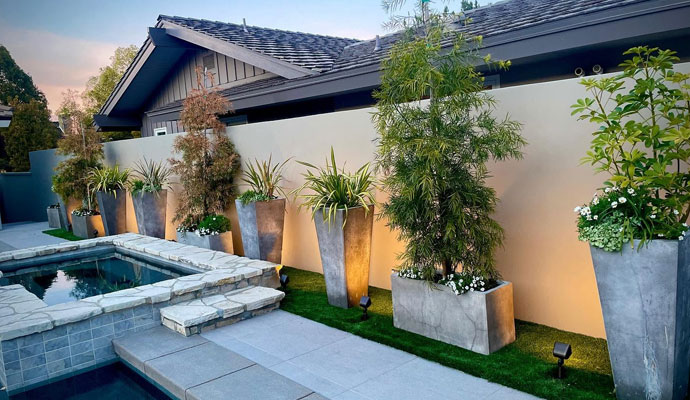 Modern backyard patio pool with landscape lighting