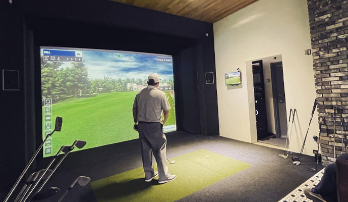 Person playing golf on an indoor simulator