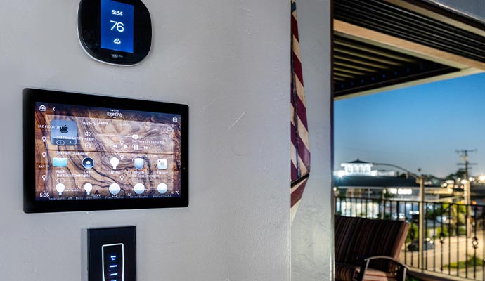 Smart home control panel and thermostat mounted on a wall Smart home control panel and thermostat mounted on a wall near a balcony with city view
