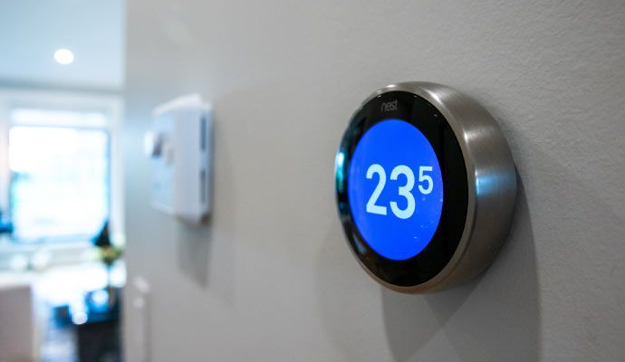 Smart thermostat displaying 23°C in modern home Wall-mounted smart thermostat displaying 23°C in a modern home