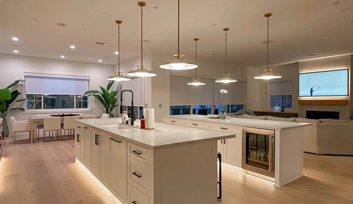 Luxury kitchen featuring brass pendant lighting, island underglow lights, and ambient fixtures.