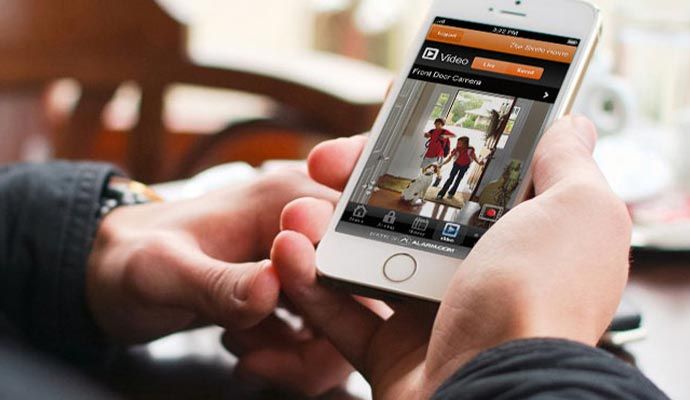 Person monitoring live video feed on smartphone