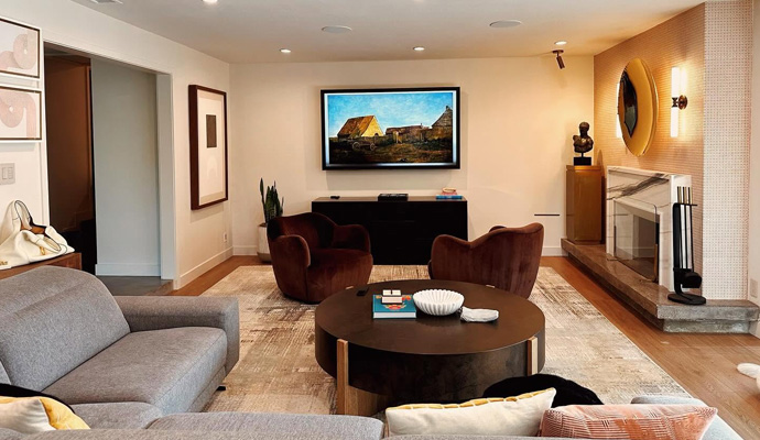 Modern living room with a media wall, television, and fireplace.