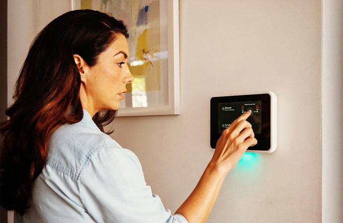 A girl using an energy-efficient smart wall thermostat
