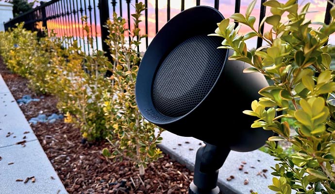Weather-resistant outdoor speaker installed among garden plants for high-quality audio