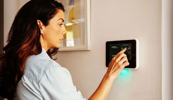 Woman adjusting smart home wall touchscreen controller