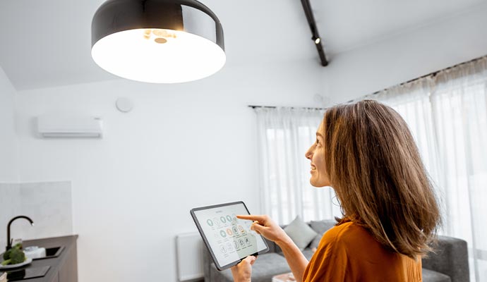 Woman controlling home lights with a digital tablet