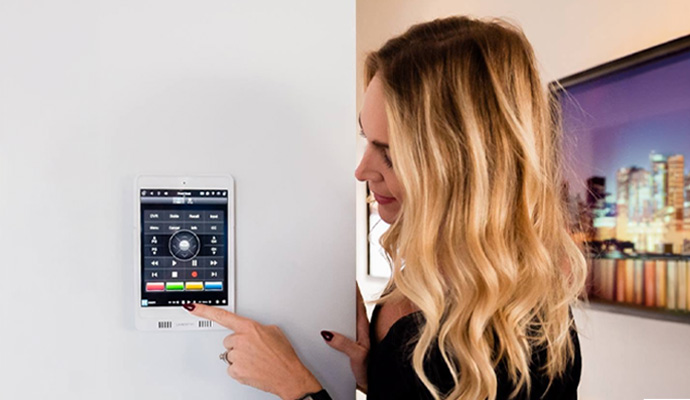 Woman using smart home wall touchscreen control panel